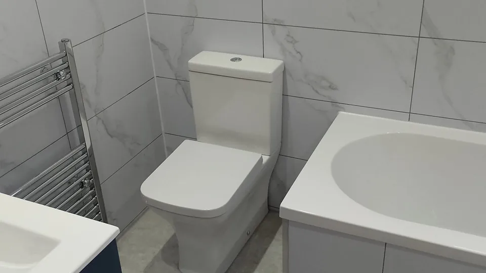 White toilet beside the end of a fitted bath