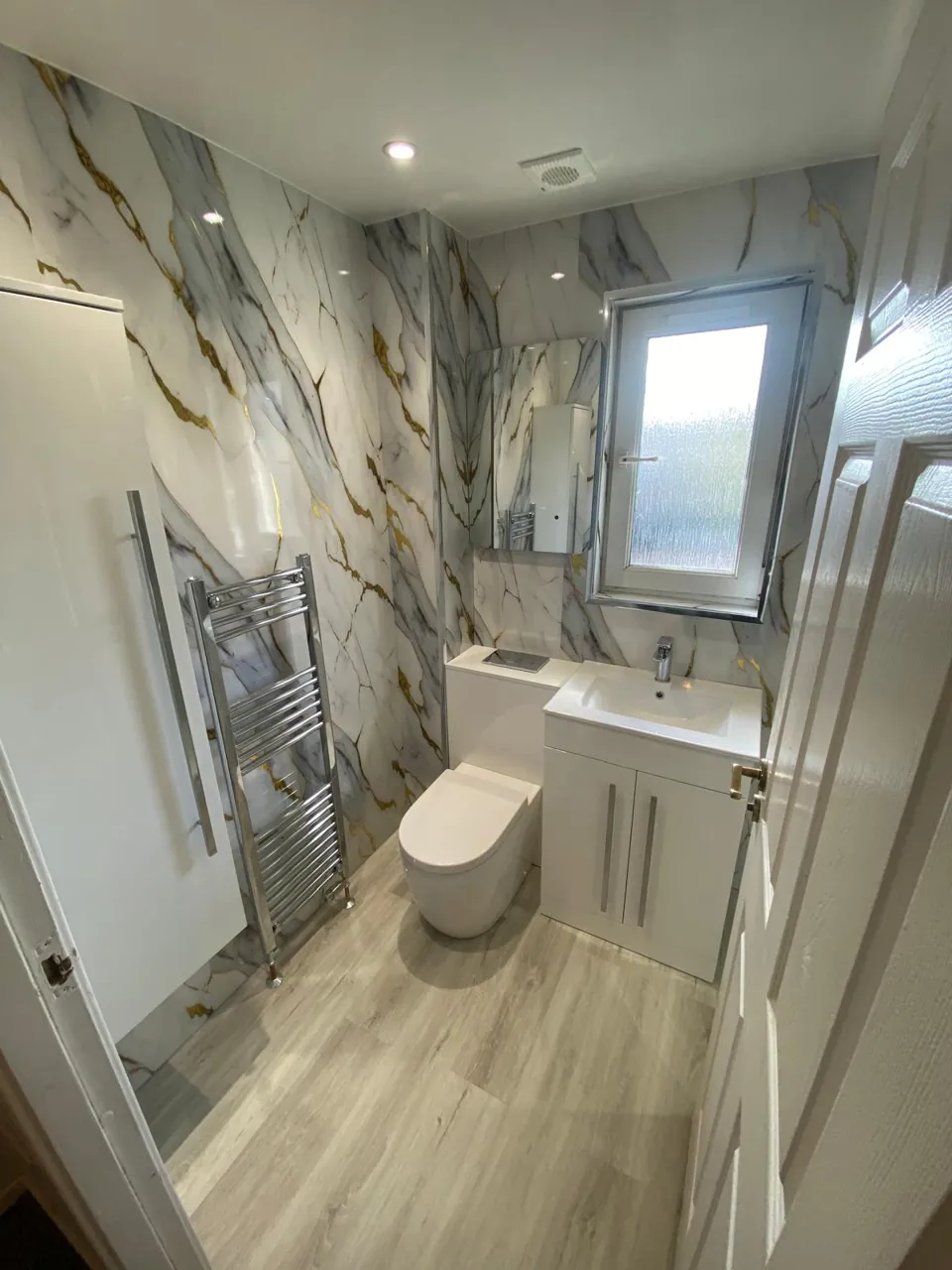 Compact shower room with gold-veined marble-effect walls