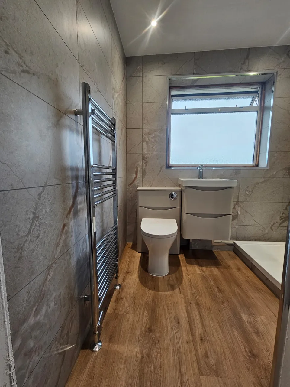 Shower room with white vanity and wood-effect flooring
